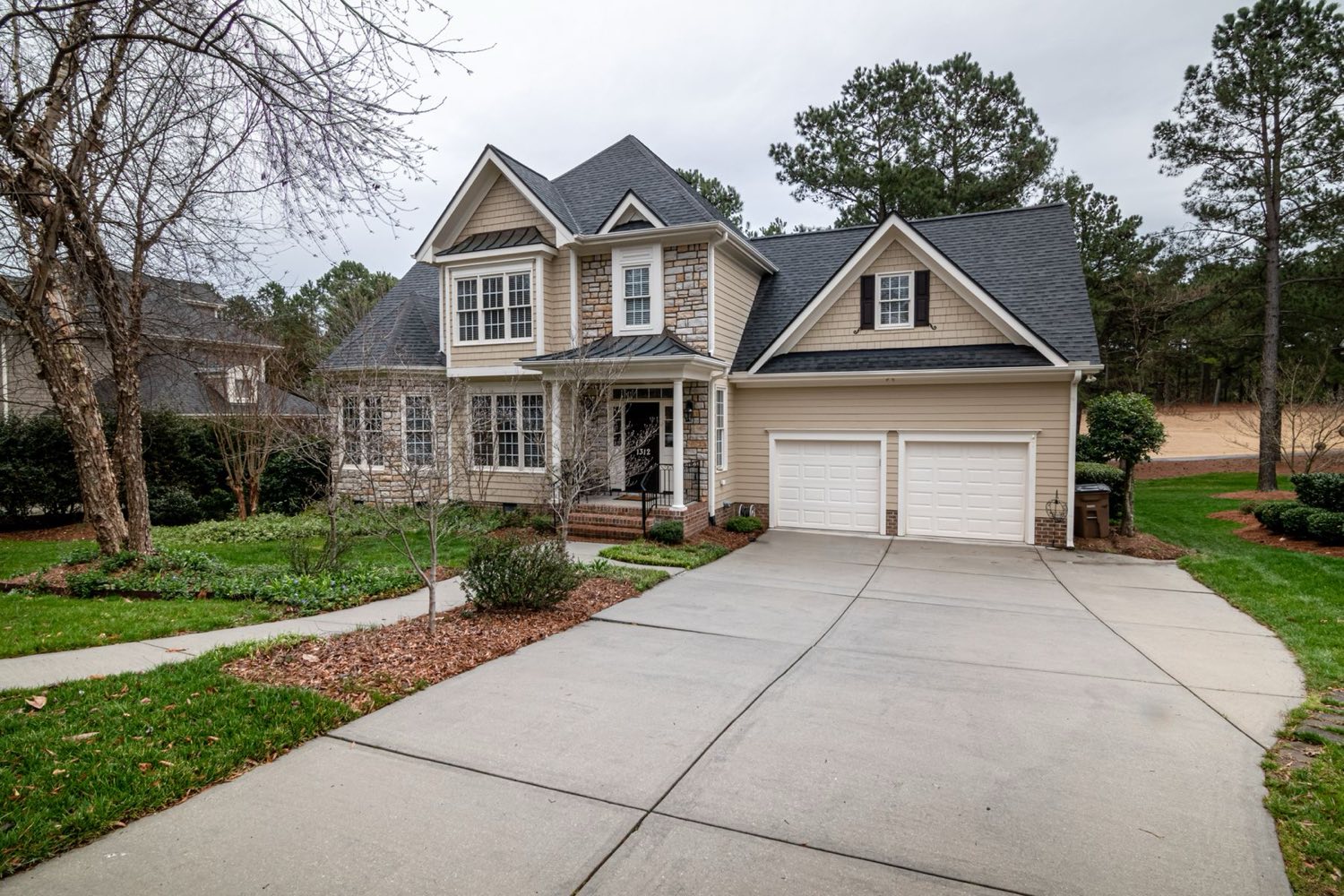 Two-story home with a wide concrete driveway and walkway